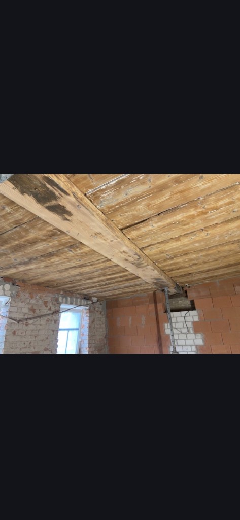 Denkmalgeschützte Holzdecke mit Balken während der Restaurierung